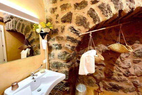 a bathroom with a sink and a stone wall at Dammuso Civulia Pantelleria in Pantelleria
