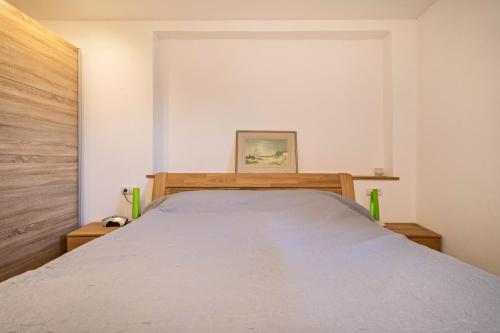 a bedroom with a large bed with a wooden headboard at Ferienwohnung Tannenblick in Höchst