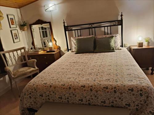 a bedroom with a bed and a chair and a mirror at Casa Corral Bouzamayor in Valdoviño