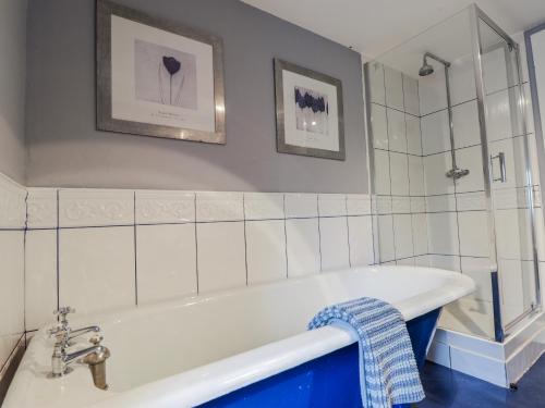 a bath tub in a bathroom with white tiles at Achnagonlin House in Grantown on Spey