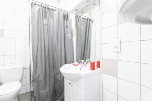 a white bathroom with a sink and a shower at Le Béout rez-de-jardin in Lourdes