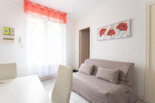 a living room with a couch and a window at Le Béout rez-de-jardin in Lourdes