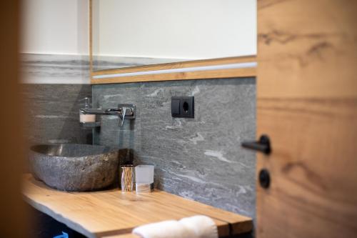 a bathroom with a stone sink on a counter at Bergsteiger Apartment - Patleidhof in Naturno