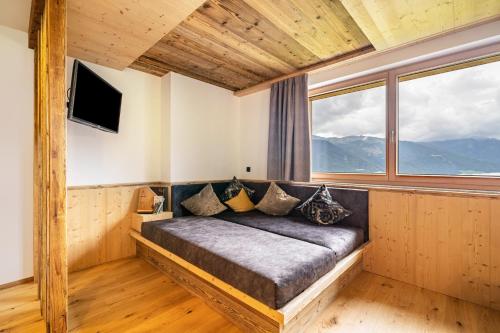 a bed in a room with a large window at Bergsteiger Apartment - Patleidhof in Naturno