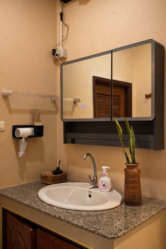 a bathroom counter with a sink and a mirror at Lilo House, Thaimueang Beach in Thai Muang