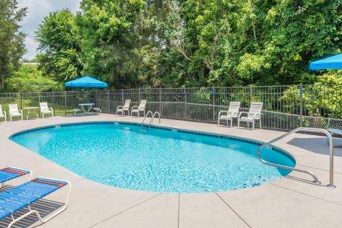 a swimming pool with chairs and a table at Days Inn by Wyndham Knoxville East in Knoxville