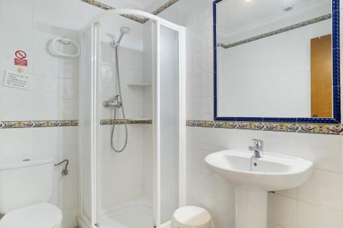 a white bathroom with a shower and a sink at Casa Paqui Bustos 1 in Conil de la Frontera
