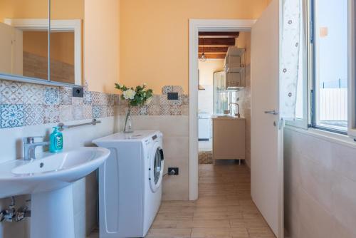 a bathroom with a sink and a washing machine at Casa Vacanza Brucoli Mare 2 in Brucoli