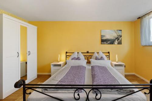 two beds in a bedroom with yellow walls at Reiselust in Stockach