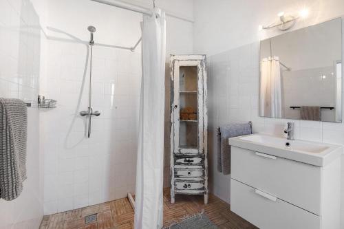 a white bathroom with a sink and a shower at Casa Papaya in Vila Nova De Cacela