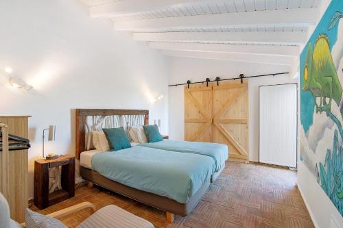a bedroom with two beds and a sliding barn door at Casa Papaya in Vila Nova De Cacela