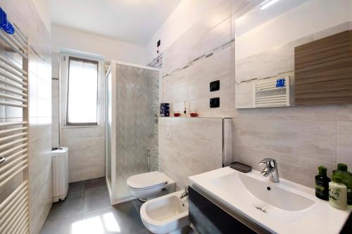 a white bathroom with a sink and a toilet at Appartamento 8 Il Tornante in Nesso