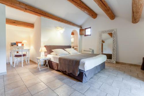 a bedroom with a large bed and a mirror at La Grange Bessac in Violès