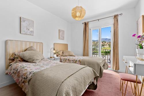 a bedroom with two beds and a desk and a window at Front Line Beach Townhouse Estepona in Estepona