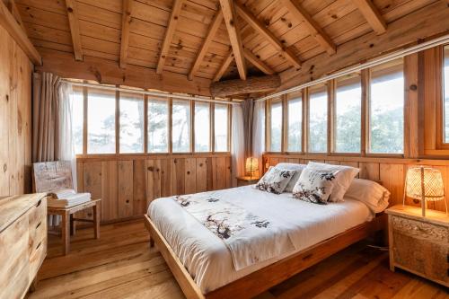 a bedroom with a bed in a room with windows at Villa Chan-Ly in Lacanau