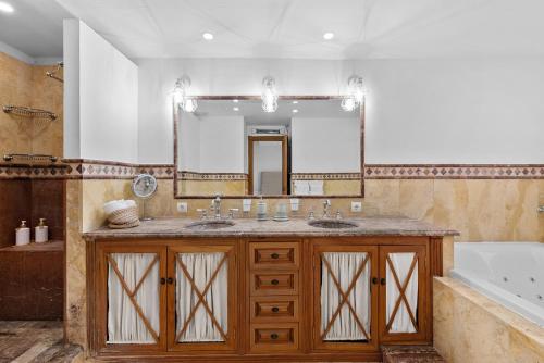 a bathroom with two sinks and a large mirror at Front Line Beach Townhouse Estepona in Estepona