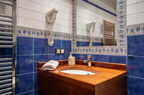 a bathroom with a sink and blue and white tiles at C de Alborada del eo in Villameitide