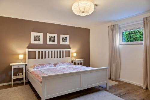 a bedroom with a bed and two tables and a window at Ferienwohnung Gabler in Möhnesee