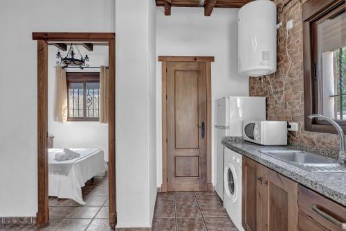 a kitchen with a sink and a refrigerator at Casas al Alba 2 in Zahora