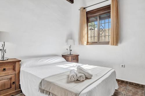 a bedroom with a bed with two towels on it at Casas al Alba 2 in Zahora