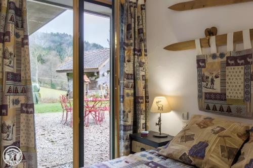 a bedroom with a bed and a sliding glass door at Gîte Chez Mayon in Orcier