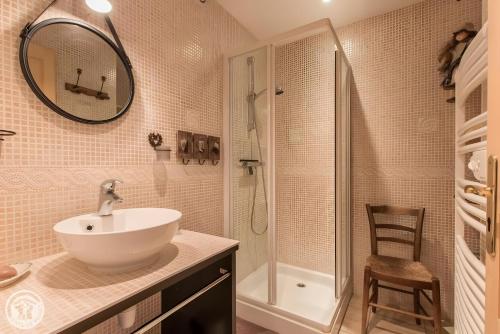 a bathroom with a sink and a shower and a mirror at Gîte Chez Mayon in Orcier