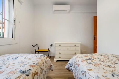 a bedroom with two beds and a dresser and a window at Ca La Lola in Llorenç del Penedes