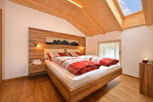 a bedroom with a large bed with red pillows at Moarhof in Rosa