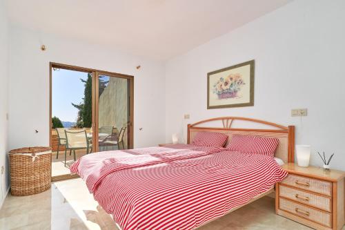 a bedroom with a bed with a red and white striped sheets at Apartamento Ombú in La Herradura