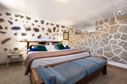 a bedroom with a bed and a stone wall at Esencia Eco-rústico Adults Only in El Charco