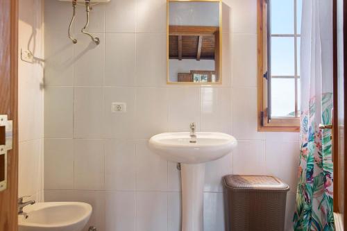 a white bathroom with a sink and a mirror at Mirador de la Abuela in Gáldar