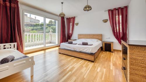 a bedroom with a bed and a large window at Costacabana - Villa Primavera in Lloret de Mar