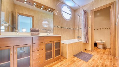 a bathroom with a sink and a tub and a toilet at Costacabana - Villa Primavera in Lloret de Mar