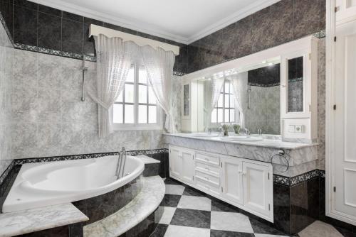 a bathroom with a tub and a sink at Villa Carmen in Hozanejos