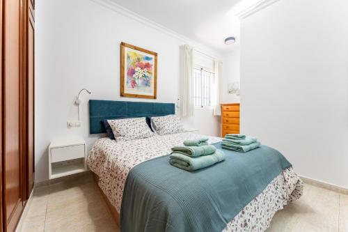 a bedroom with a bed with green towels on it at 234 Parque playa La cala in La Cala de Mijas