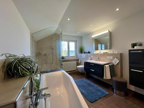 a bathroom with a tub and a sink and a toilet at Ferienwohnung Klosterblick in Öhningen