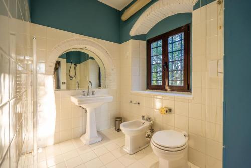 a bathroom with a sink and a toilet and a window at Villa Assolata in Pietraviva