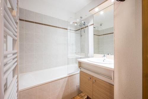 a bathroom with a sink and a tub and a shower at Appartement Ski Valmeinier in Valmeinier
