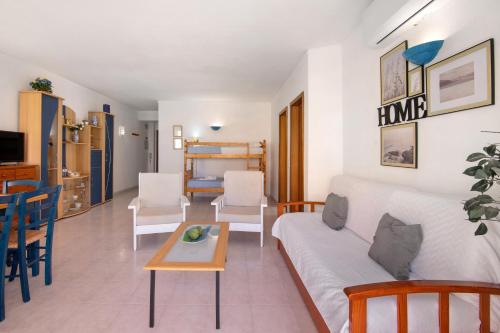 a living room with a white couch and a table at Casa Néctar in Armação de Pêra