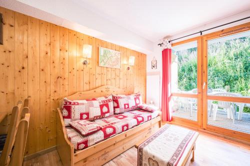 a bedroom with wooden walls and a bed with pillows at Appartement Ski Valmeinier in Valmeinier