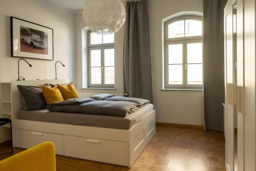 a bed in a room with two windows at Ferienwohnung Lindner 1 in Weimar