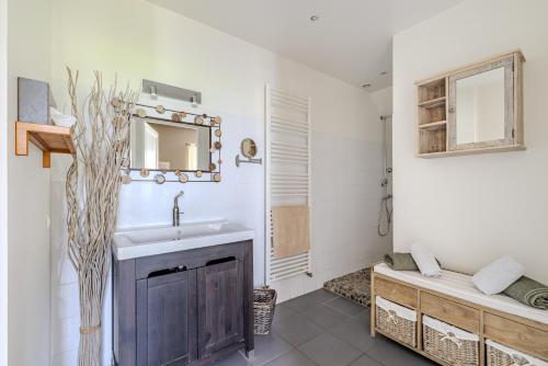 a bathroom with a sink and a mirror at Maison Les Marronniers in Montagne