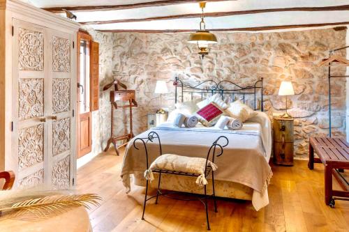 a bedroom with a bed and a stone wall at La Casuna in Olba