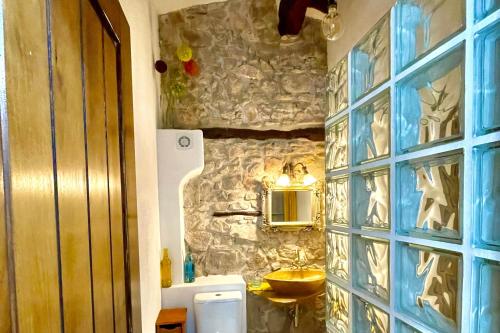 a bathroom with a sink and a stone wall at La Casuna in Olba