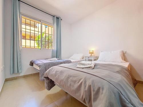 two beds in a room with a window at Albatros Playa 3 - 1207 in Mar de Cristal