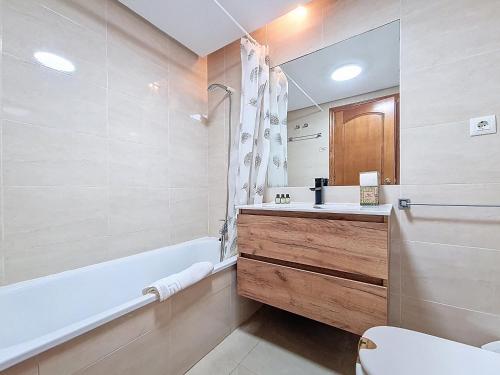 a bathroom with a sink and a tub and a toilet at Albatros Playa 3 - 1207 in Mar de Cristal