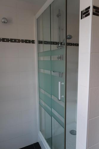 a shower with glass doors in a bathroom at La Fée Maison, chambres d'hôtes in Plouër-sur-Rance