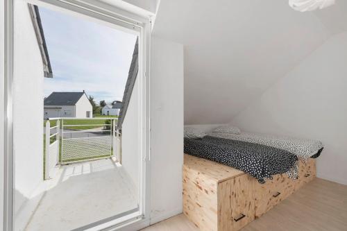 a small bedroom with a bed and a window at Les terrasses de Kerhos in Camaret-sur-Mer