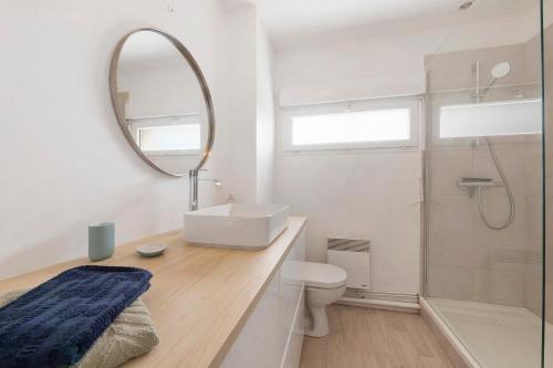 a bathroom with a sink and a mirror and a toilet at Les terrasses de Kerhos in Camaret-sur-Mer