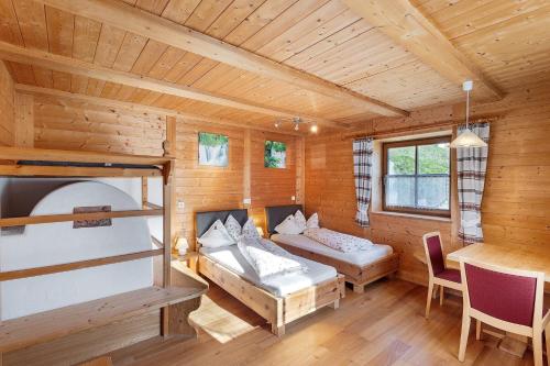 a log cabin with two beds and a table at New - Steinhof Val di Mezzo in Val di Mezzo